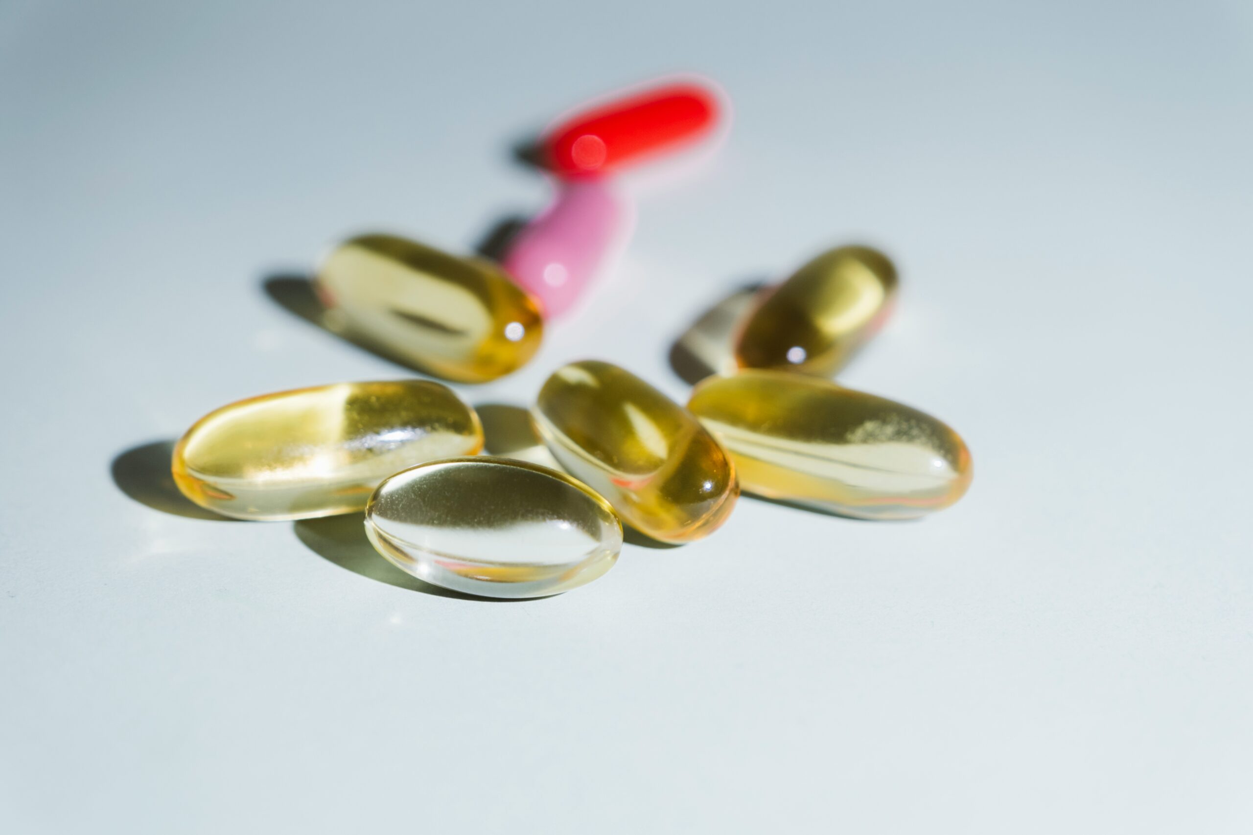 Different types of supplements lying on a blue-gray table.